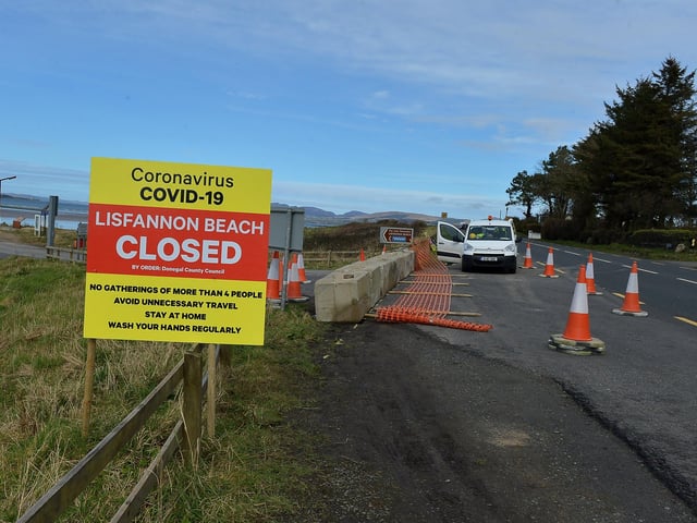 Donegal County Council workers place concrete bollards at the entrance to Lisfannon beach at Fahan Thursday afternoon last. The beach has been closed to the public. . DER1320GS - 003