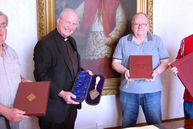 Bishop Donal McKeown hands over the church artefacts to representatives of Aras Cholmcille.
