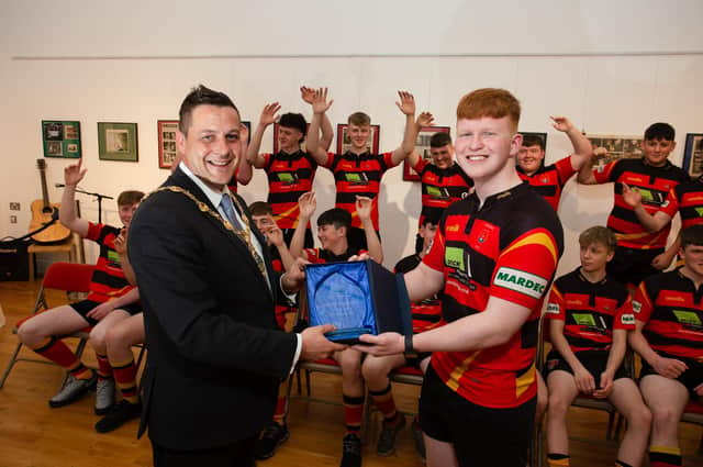 Mayor of Derry City and Strabane District Council, Alderman Graham Warke, presents Strabane Rugby Club U16 team captain Tom McGilloway with a piece of crystal to mark their achievement of winning the Ulster Plate.
