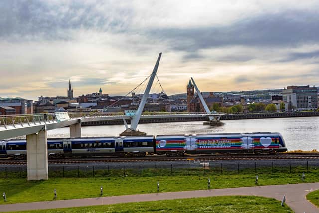 The Derry to Belfast train passes the city’s iconic Peace Bridge at Ebrington. Photo: Tony Monaghan.