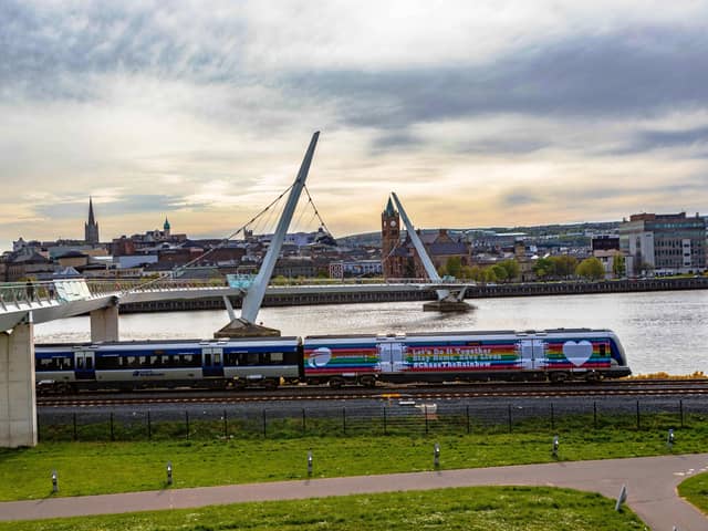 The Derry to Belfast train passes the city’s iconic Peace Bridge at Ebrington. Photo: Tony Monaghan.