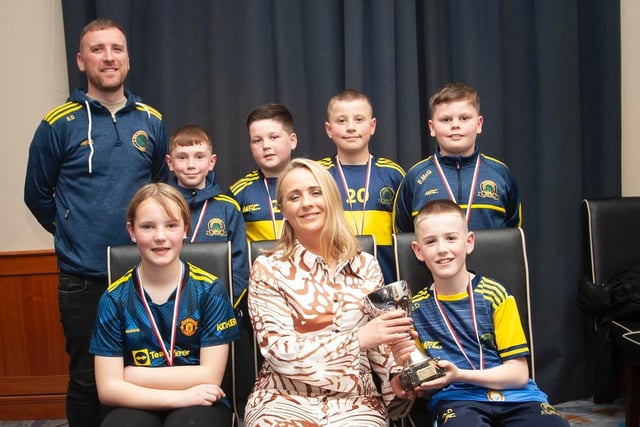 Caroline Casey, O'Neill's Sportswear presenting the U10 Winter Plate to Don Boscos FC at Thursday night's D&D awards. At back is coach Eamon Daly. Picture by Jim McCafferty