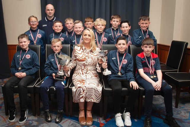 Caroline Casey, O'Neill's Sportswear presenting the U10 Summer Cup and Winter Cup to Clooney FC at Thursday night's D&D awards. At back is coach Gavin Bond. Picture by Jim McCafferty