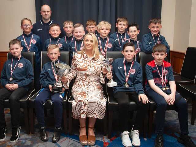 Caroline Casey, O'Neill's Sportswear presenting the U10 Summer Cup and Winter Cup to Clooney FC at Thursday night's D&D awards. At back is coach Gavin Bond. Picture by Jim McCafferty