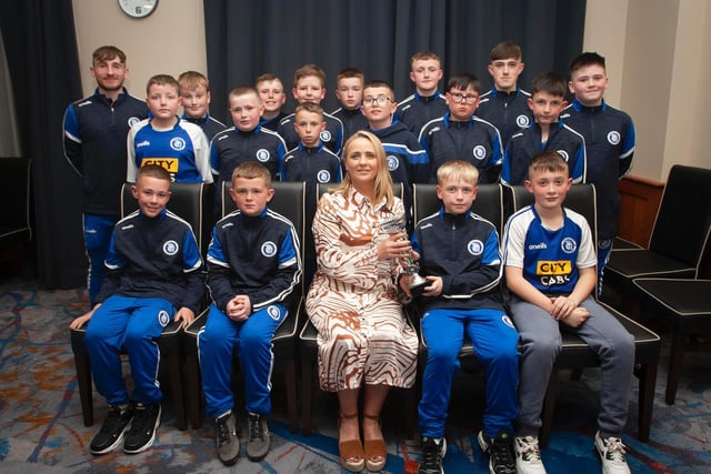 Caroline Casey, O'Neill's Sportswear presenting the U11 D&D Winter Cup to Trojans FC at Thursday night's D&D awards. At back are coaches Ronan Pyne and Liam Shiels. Picture by Jim McCafferty