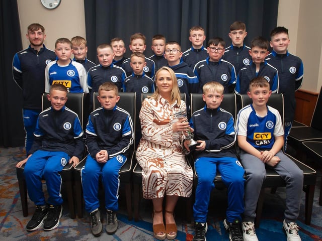 Caroline Casey, O'Neill's Sportswear presenting the U11 D&D Winter Cup to Trojans FC at Thursday night's D&D awards. At back are coaches Ronan Pyne and Liam Shiels. Picture by Jim McCafferty