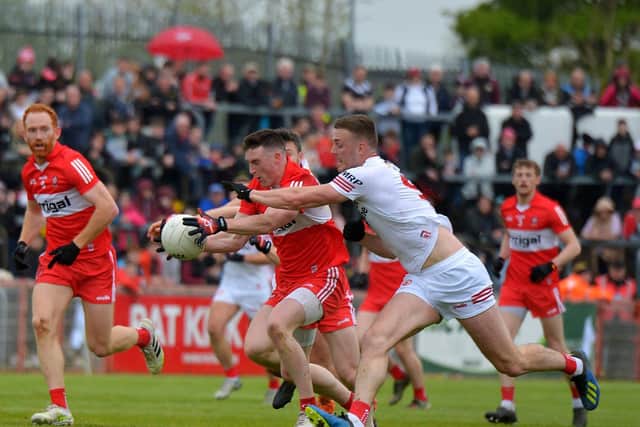 Tyrone’s Brian Kennedy attempts to dispossess Derry’s Gareth McKinless at Healy Park on Sunday afternoon last.  Photo: George Sweeney.  DER2218GS – 002
