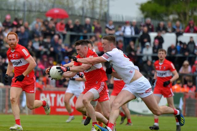 Tyrone’s Brian Kennedy attempts to dispossess Derry’s Gareth McKinless at Healy Park on Sunday afternoon last.  Photo: George Sweeney.  DER2218GS – 002