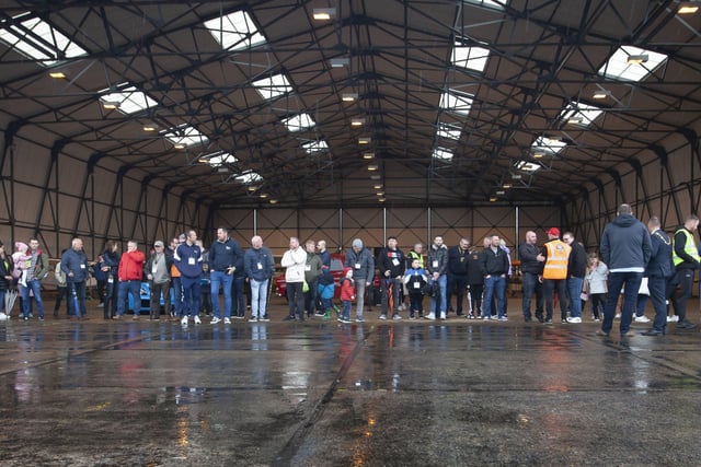 Car enthusiasts taking shelter from the rain in one of the hangars at City of Derry Airport during Saturday morningâ€TMs Bear Run 74 VIP event.