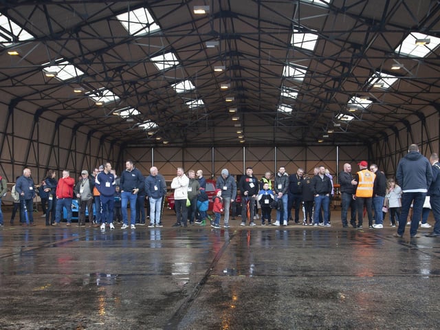 Car enthusiasts taking shelter from the rain in one of the hangars at City of Derry Airport during Saturday morningâ€TMs Bear Run 74 VIP event.