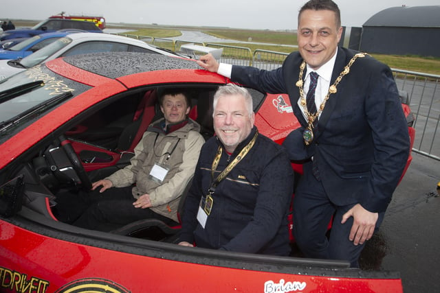 Benjamin Thompson gets to try out Des Adamâ€TMs C8 Corvette at Saturayâ€TMs VIP event. On right is Mayor, Graham Warke.