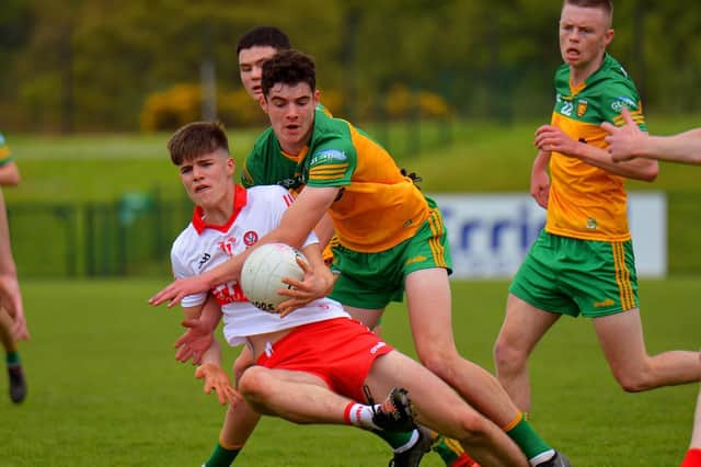 Buncrana man Sean McLaughlin grapples with Ryan McNicholl during the Ulster Minor Championship game between Derry and Donegal at Owenbeg on Sunday afternoon last. Photo: George Sweeney. DER2218GS – 023