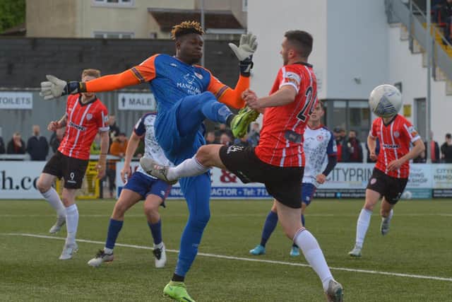 The alert Joseph Anang gets to the ball ahead of Danny Lafferty during Monday night's top of the table clash at Brandywell. Photo by George Sweeney.
