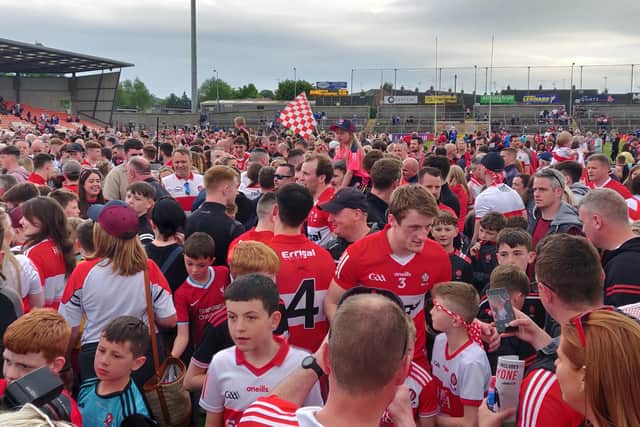 Fans and players celebrate on the Athletic Grounds pitch after Sunday's victory over Monaghan.