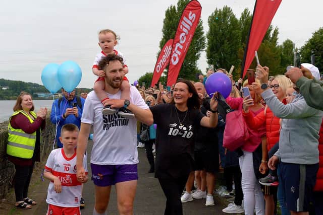 Danny Quigley’s partner Emear and sons Jack and Malachi accompany his on his arrival at Destined after completing a gruelling 10 Ironman Triathlons in 10 days in memory of his dad for charities.  Photo: George Sweeney / Derry Journal.  DER2135GS – 020