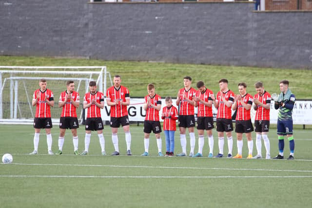 Derry City players take part in a minute's applause for lifelong club volunteer and supporter Edgar McCormack who sadly was laid to rest on Friday morning.