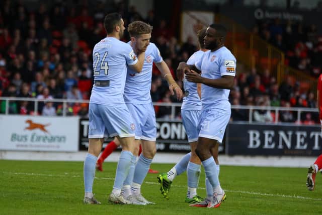 James Akintunde and Danny Lafferty congratulate Jamie McGonigle who levelled the game with his 10th goal of the season. Photograph by Kevin Moore.