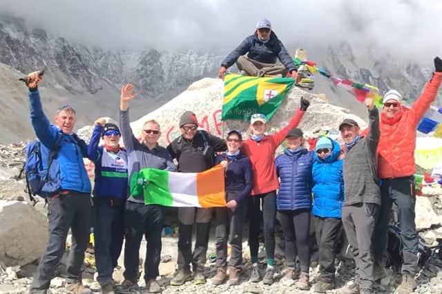Jennifer (holding the flag on right) at Mt Everest Base Camp with the rest of the team.