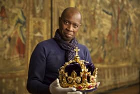 Clive Myrie holding ‘Henry’s Crown’, a replica of Henry VIII’s original crown in the Great Hall of Hampton Court Palace