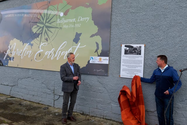 Colr Conor Heaney, Chair of DCSDC Business and Culture Committee (right) unveils a mural commemorating the 90th Anniversary of the landing of Amelia Earhart in Derry on the gable wall of the Gallaigh Co-Op on Friday afternoon last. Included in the photograph is Cathal Crumley, Community Restorative Justice.  Photo: George Sweeney.  DER2220GS – 064
