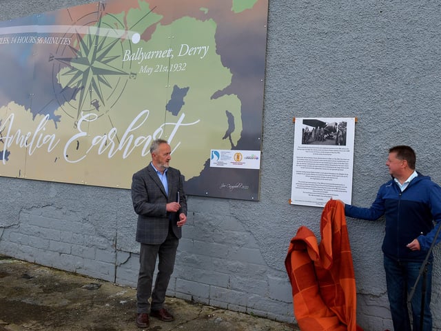Colr Conor Heaney, Chair of DCSDC Business and Culture Committee (right) unveils a mural commemorating the 90th Anniversary of the landing of Amelia Earhart in Derry on the gable wall of the Gallaigh Co-Op on Friday afternoon last. Included in the photograph is Cathal Crumley, Community Restorative Justice. Photo: George Sweeney. DER2220GS – 064