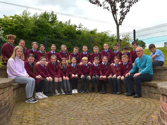 Mr Carlin, teacher, and learning support assistant Miss McGill with their P7 class at St John’s Primary School. DER2222GS – 033
