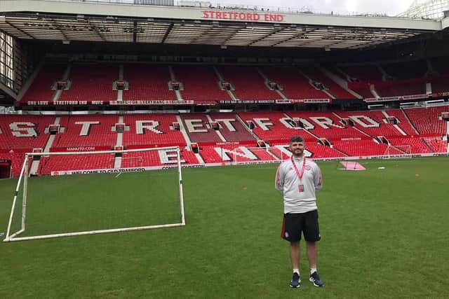 Martin Smith standing in front of the Stretford End at Old Trafford during a recent training session with the Manchester United Foundation.