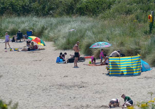 People enjoy the sunshine on Shroove beach, Inishowen, during a mini heatwave last year. DER2129GS - 064