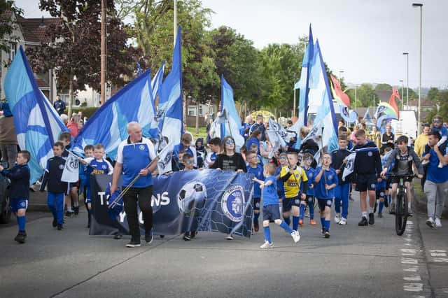 The Trojans FC squad make their way up Broadway during Fridayâ€TMs Carnival Parade.