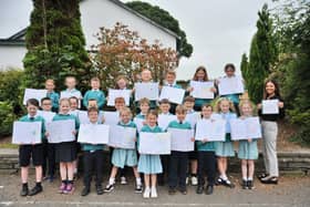 Primary four pupils with copies of the letters they wrote to David Attenborough and their teacher, Miss Kate Hutton, holding the letter David Attenborough wrote back. The pupils didn't expect the popular broadcaster to write back so they were delighted to receive it.