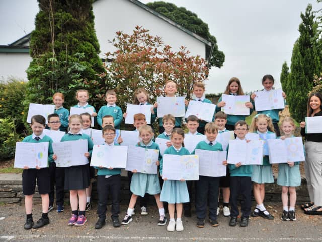 Primary four pupils with copies of the letters they wrote to David Attenborough and their teacher, Miss Kate Hutton, holding the letter David Attenborough wrote back. The pupils didn't expect the popular broadcaster to write back so they were delighted to receive it.