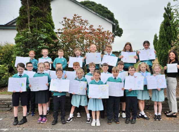 Primary four pupils with copies of the letters they wrote to David Attenborough and their teacher, Miss Kate Hutton, holding the letter David Attenborough wrote back. The pupils didn't expect the popular broadcaster to write back so they were delighted to receive it.