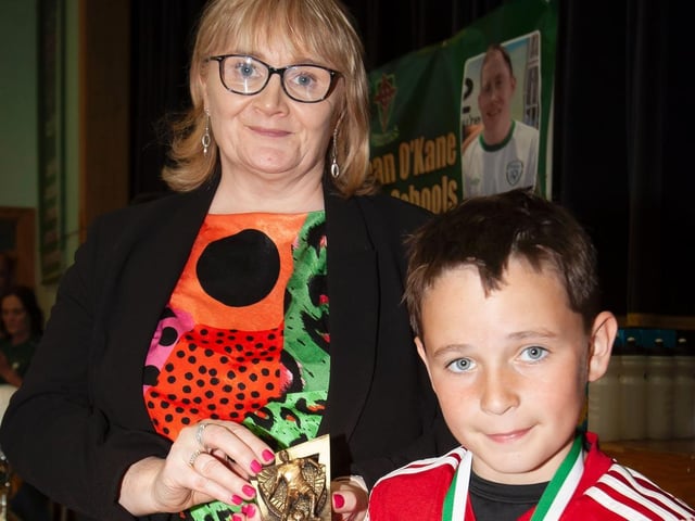 Mrs. Martina McCarron, Principal, St. Joseph's presenting the Top Goalscorer trophy to Aaron McBride, Holy Child PS.