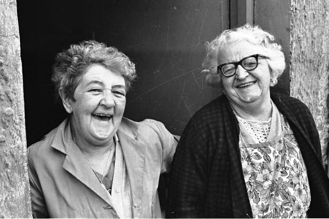 1972... Two Bogside ladies smile for the camera during the removal of barricades in the district.