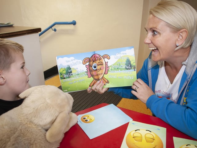 â€ ̃Fresh Little Mindsâ€TM facilitator Mary Fitzpatrick working with one of the children at Holy Child PS.