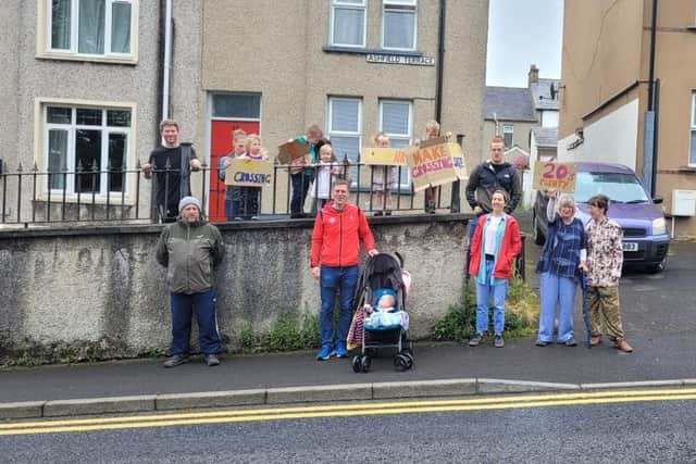 Protesters gather on Creggan Hill to highlight some of the dangers they face crossing the road to Brooke Park.