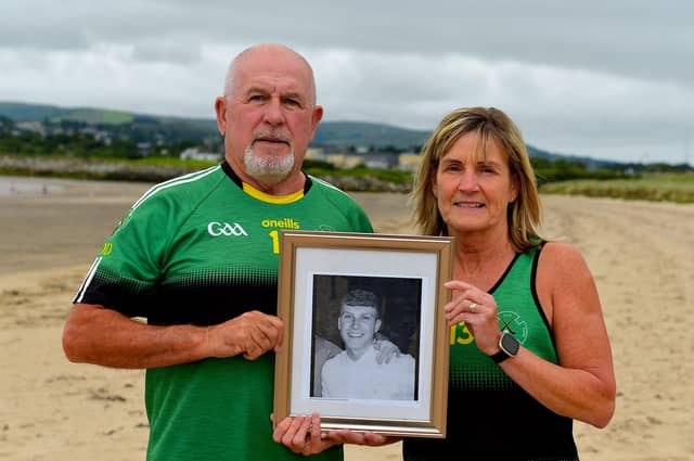 Gerry and Moira ODonnell pictured with a photograph of their late son Aodhán, a member of Na Magha hurling club, at a joint fundraising event with Waves for Mental Health held at Ludden Beach on Saturday and Sunday morning last. The ODonnell family have raised over £100,000 for mental health charities and organisations in the city in Aodháns memory. Photograph: George Sweeney. DER2228GS 001