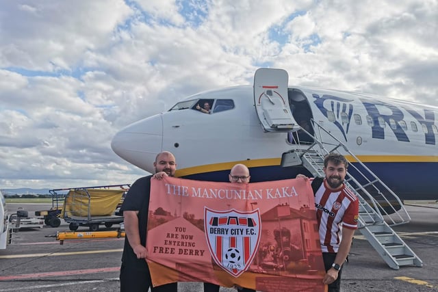 The pilot approves as Derry City fans Darran, Adrian and Conor show off the Will Patching The Mancunian Kaka flag before boarding their flight to Riga.