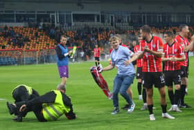 Derry City fan Leo McGlinchey gets away from two of the Riga stewards who fall to the ground in an attempt to get him off the pitch after the match. Photo by Kevin Moore.