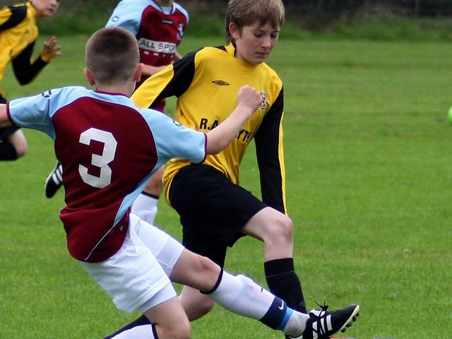 Limavady United’s Joshua Galloway, slips over a tackle from Donegal Town’s Sean Breen, In their Foyle cup under 12 game at Eglinton. INLS 12230-504MT.
