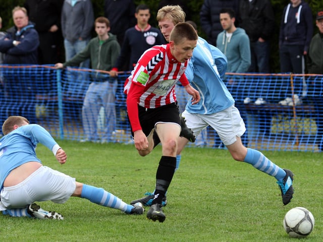 The Derry City player slips between the two Ballymena defenders , during action in their Foyle cup under 19 game at McCourt’s INLS 1230-537MT.