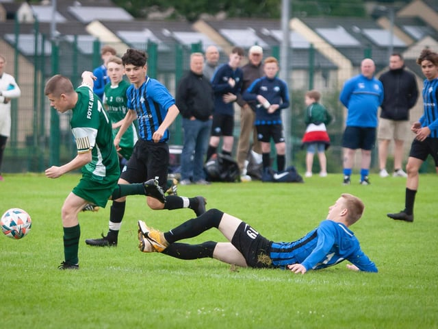 A Foyle Harps player skips away from this challenge from a Portrush midfielder, during their O'Neills Foyle Cup game. Picture by Jim McCafferty