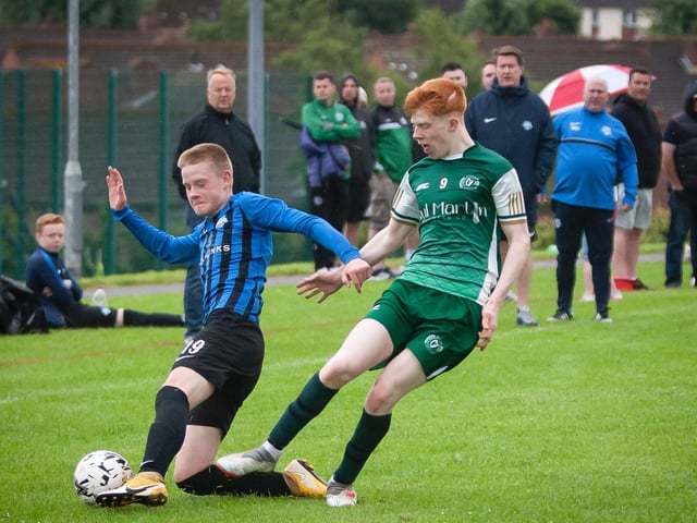A Portrush player slides in to win possession from a Foyle Harps player during their O'Neills Foyle Cup game. Picture by Jim McCafferty