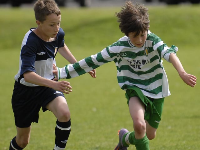 Top Of The Hill Celtic under-14's player Rory Holden holds off this challenge from a Limavady United defender during their Foyle Cup match. LS30-206KM10
