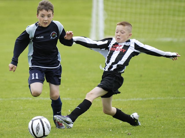 Institute under-11's player Jamie Adams skips past this tackle from a St. Oliver Plunkett defender during their Foyle Cup match. LS30-189KM10