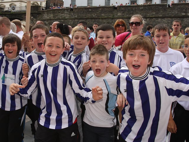 Culmore FC team members lead the cheering at the Foyle Cup parade in Guildhall Square. LS2910-580MT.