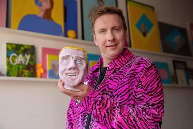 Joe Lycett holding his piece ‘Chris’ in his studio in Birmingham