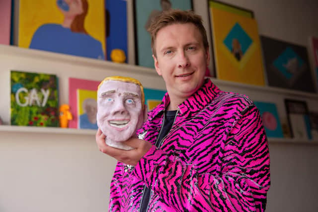 Joe Lycett holding his piece ‘Chris’ in his studio in Birmingham