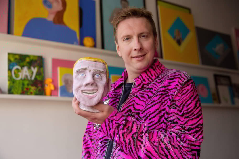 Joe Lycett holding his piece ‘Chris’ in his studio in Birmingham