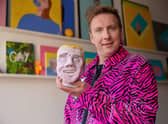 Joe Lycett holding his piece ‘Chris’ in his studio in Birmingham